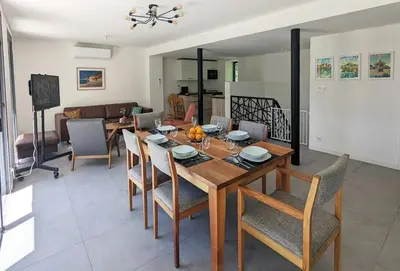 a dining room and living room with a table and chairs at Évasion Moderne en Provence in Lambesc