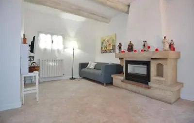 a living room with a blue couch and a fireplace at Maison de Village avec jardin dans Centre historique in Eyguières