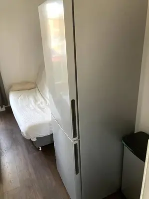 a white refrigerator in a room with a bed at Appartement entier au RDC in Salon-de-Provence