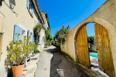 an alley with wooden doors in a building at La Maison Maupas in Ménerbes
