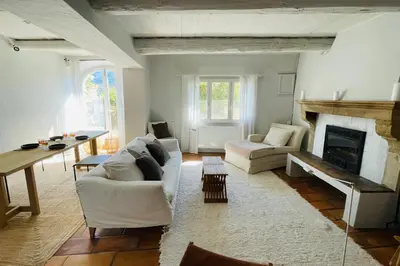a living room with white furniture and a fireplace at La Maison Maupas in Ménerbes