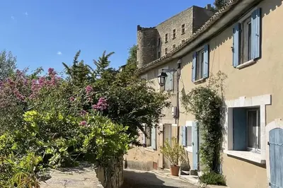 a building with flowers and plants on a street at La Maison Maupas in Ménerbes