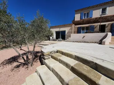 a stone retaining wall in front of a house at Havre de paix au bord des Alpilles in Eyguières