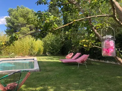 two chairs and a swimming pool in a yard at Hope, villa à Aix en Provence in Aix-en-Provence