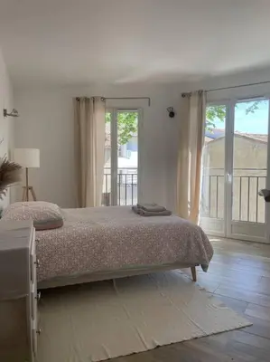 a bedroom with a bed and a large window at Appartement Confortable & Lumineux in Lambesc