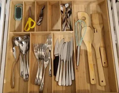 a wooden drawer filled with utensils and scissors at Appartement Confortable & Lumineux in Lambesc