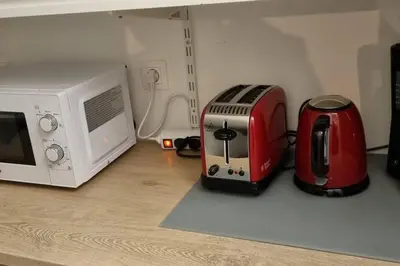 a microwave and a toaster on a kitchen counter at Appartement Confortable & Lumineux in Lambesc