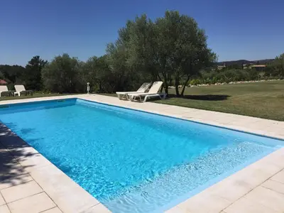 a swimming pool with two lounge chairs in a yard at La Bastide au Ventoux in Bédoin