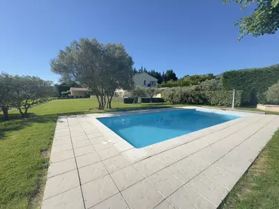 a swimming pool with a concrete walkway next to a yard at La Bastide au Ventoux in Bédoin