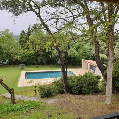a house with a wooden deck with a table at Appartement dans campagne aixoise in Ventabren