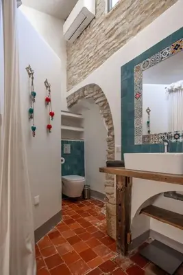 a bathroom with a sink and a toilet and a mirror at Grande maison de charme au coeur de Goult in Goult