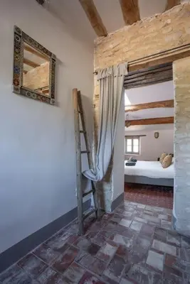 a bedroom with a bed and a ladder in a room at Grande maison de charme au coeur de Goult in Goult