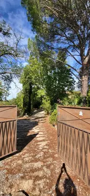 a pair of wooden gates on a dirt road at Une maison de famille dans le Luberon in Bonnieux