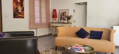 a living room with a couch and a table at Une maison de famille dans le Luberon in Bonnieux
