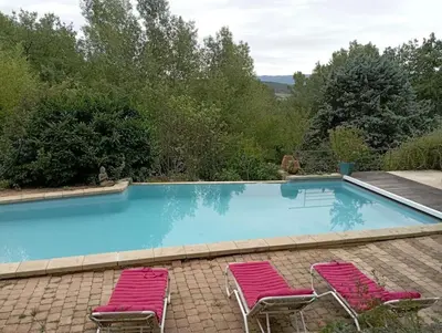 two pink chairs and a swimming pool with at maisonnette provençale piscine le petit colibri in Les Cordiers