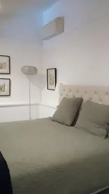 a white bedroom with a large bed with a headboard at maisonnette provençale piscine le petit colibri in Les Cordiers