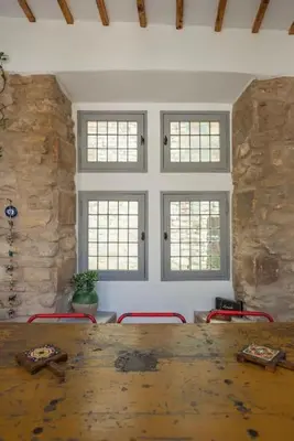 a dining room with a wooden table and four chairs at Maison d'exception au cœur de Goult in Goult