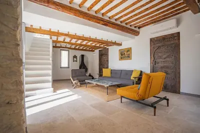 a living room with a yellow chair and a couch at Maison d'exception au cœur de Goult in Goult