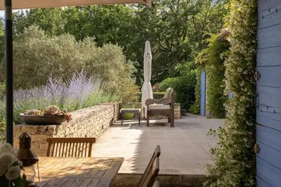 a patio with an umbrella and a table and chairs at Superbe Mas provençal, entre Gordes et Roussillon in Murs