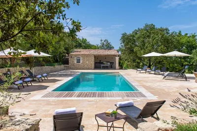 a swimming pool with chairs and a villa at La Becasse Heritage Pool Manor in Bonnieux