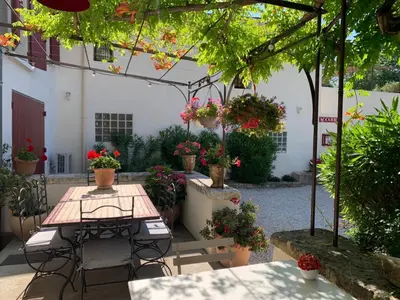 a patio with a table and chairs and flowers at Chambres d'hôtes 