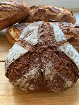 a loaf of bread sitting on top of a cutting board at Chambres d'hôtes 
