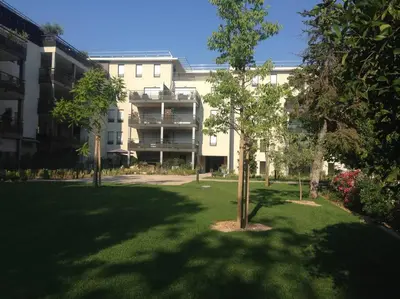 a building with a tree in the middle of a yard at Bel appartement 1 chambre - résidence de standing in Aix-en-Provence
