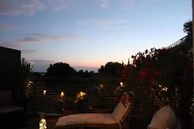 a patio with a couch and some plants and lights at Bel appartement 1 chambre - résidence de standing in Aix-en-Provence