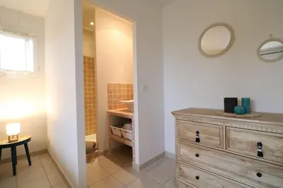 a bathroom with a wooden dresser and a mirror at Villa l'Hestia avec piscine à l'Isle-sur-Sorgue in LʼIsle-sur-la-Sorgue