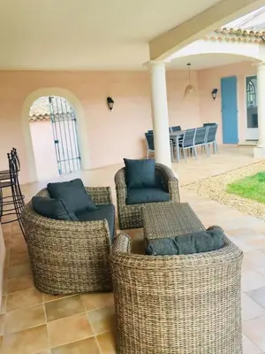 a patio with two wicker chairs and a table at Villa l'Hestia avec piscine à l'Isle-sur-Sorgue in LʼIsle-sur-la-Sorgue
