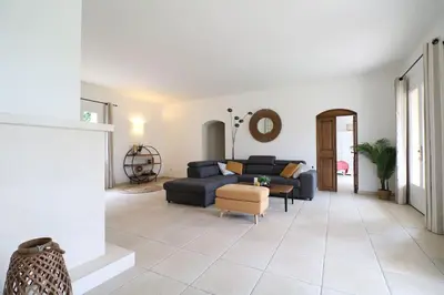 a living room with a blue couch and a chair at Villa l'Hestia avec piscine à l'Isle-sur-Sorgue in LʼIsle-sur-la-Sorgue