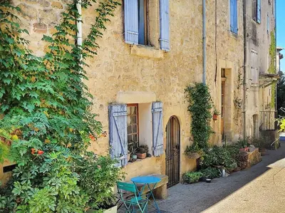 a stone building with a blue table in front of it at Les voûtes du vieux village in Lauris