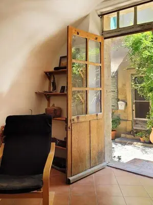 a room with a door and a chair and a window at Les voûtes du vieux village in Lauris