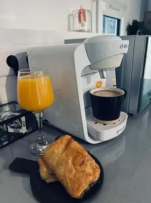 a mixer and a glass of orange juice and a piece of food at Studio Oasis de paix centre Aix en Provence in Aix-en-Provence