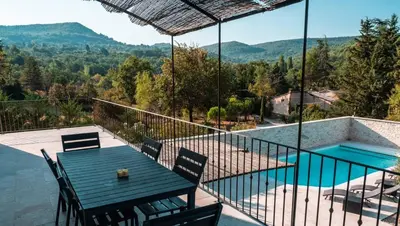 a patio with a table and chairs and a swimming pool at La Petite Colline in Apt