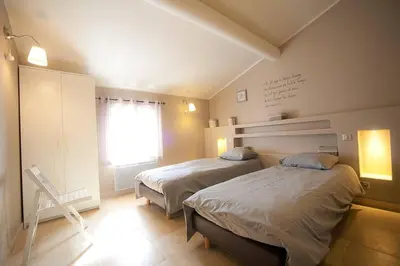 a bedroom with two beds and a window at La Petite Colline in Apt