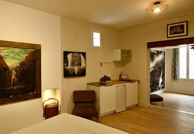 a room with a kitchen and a living room at Suite dans maison d'artiste in LʼIsle-sur-la-Sorgue