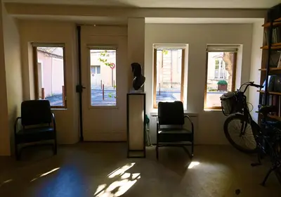 a room with two chairs and a bike on the wall at Suite dans maison d'artiste in LʼIsle-sur-la-Sorgue