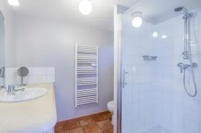 a bedroom with a bed and a large window at Les Douze Oliviers in Ménerbes