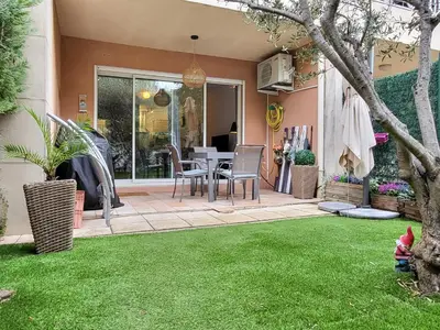 a patio with a table and chairs in a yard at Le temps d'un instant in Salon-de-Provence