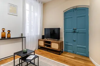 a living room with a blue door and a tv at Suite cosy dans le centre historique in Aix-en-Provence