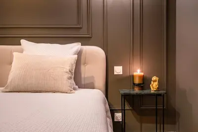 a bedroom with a bed with a candle on a side table at Suite cosy dans le centre historique in Aix-en-Provence