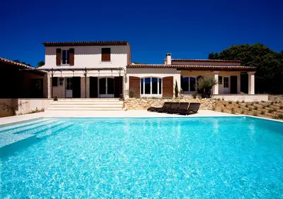 a villa with a swimming pool in front of a house at La Collina De Rve in Apt