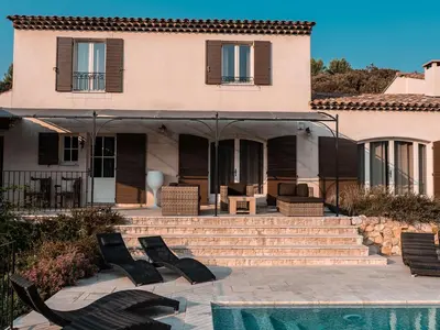 a house with chairs and a pool in front of it at La Collina De Rve in Apt