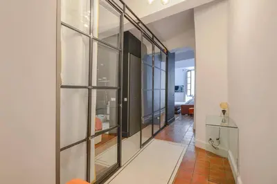 a hallway with glass windows and a living room at Élégant Appartement Standing à 3min du Cours Mirabeau in Aix-en-Provence
