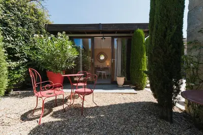 a patio with chairs and a table in a garden at Studio at Mas Naste in Eygalières