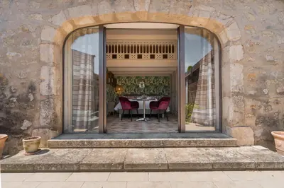 an archway leading to a patio with a table and chairs at Studio at Mas Naste in Eygalières