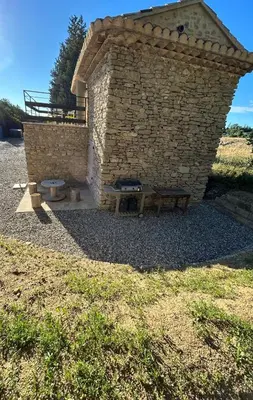 a brick building with a picnic table and a bench at Charmante maison Provençale avec grand jardin in LʼIsle-sur-la-Sorgue