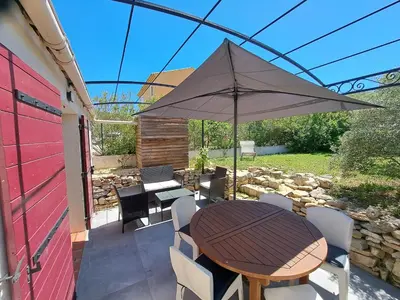 a table and chairs with an umbrella on a patio at Gîte Le Dodo in Lançon-Provence