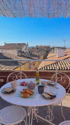 a white table with food on top of a balcony at Appartement Vieille ville 55 m2 avec Terrasse 16m2 et 2chambres Vraie Climatisation in Aix-en-Provence